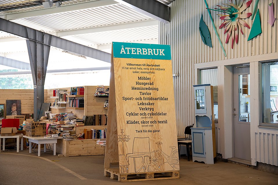 En stor träskylt omgiven av prylar.