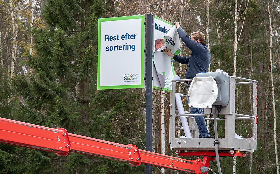 En man klistrar över skylten brännbart till rest efter sortering