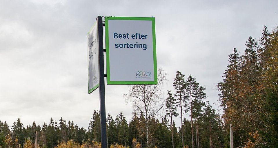 Skylt med texten Rest efter sortering sticker upp ur en höstfärgad skog.